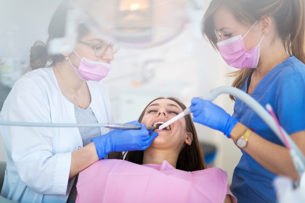 Dentist and dental assistant working on patient