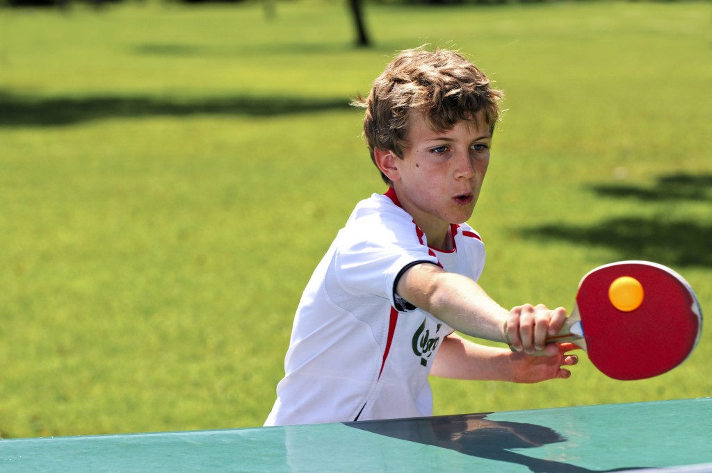 child playing table tennis outdoors