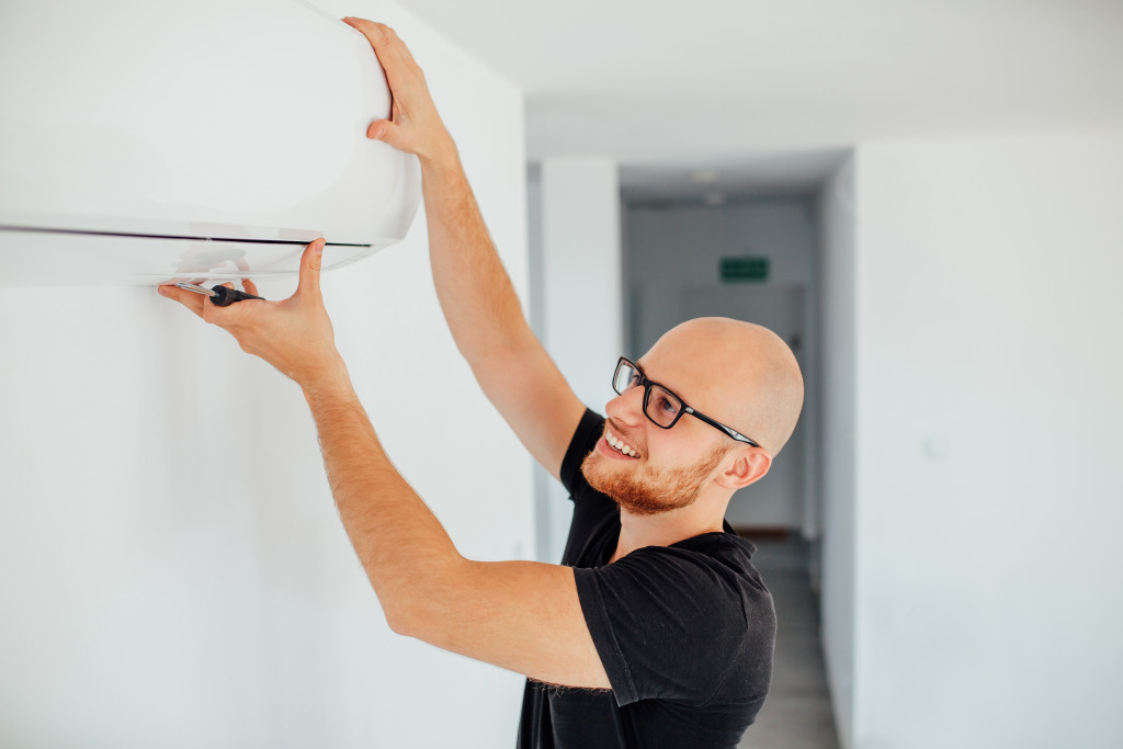 a man holding an air conditioning unit with hands