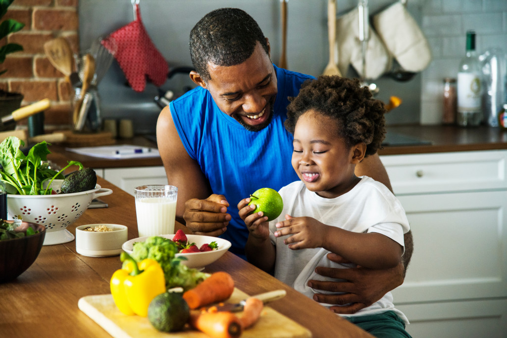 A father and son in the dining room, eating fruits