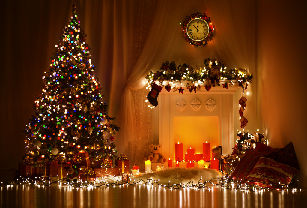 A Christmas tree and fireplace covered in Christmas lights