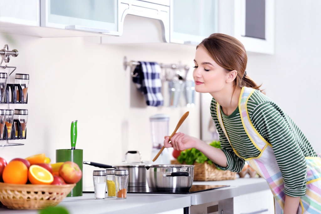 a woman wearing apron cooking in the kitchen