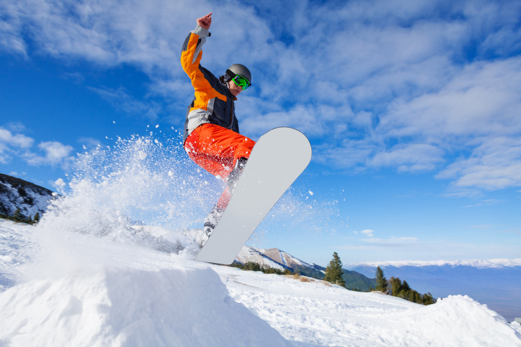 man snowboarding alone in a snow-covered hill