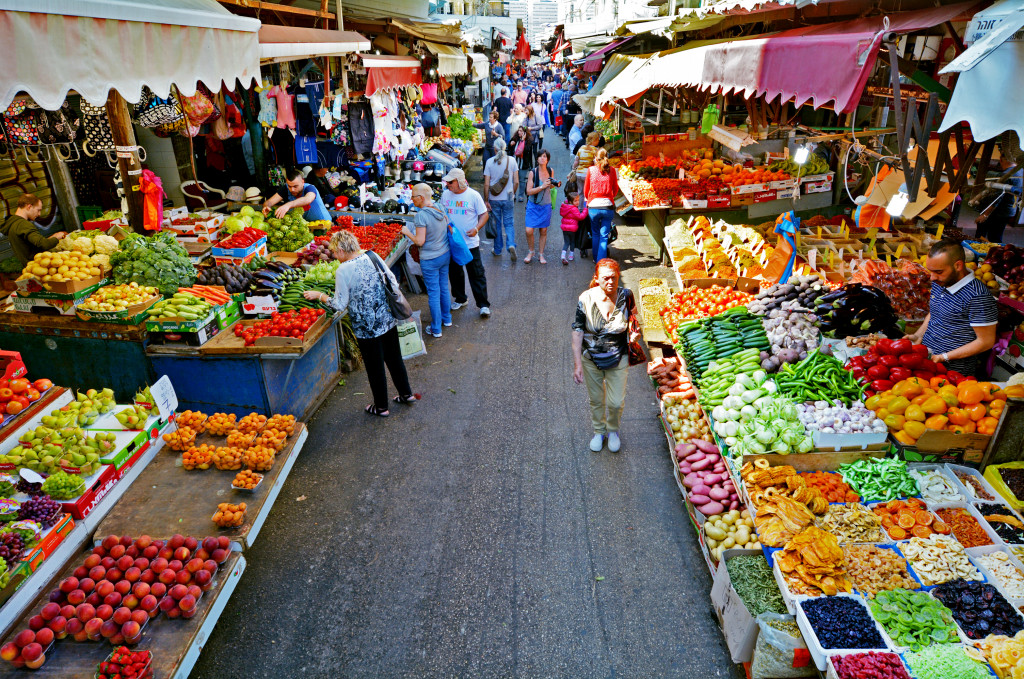 People buying fruits and vegetables in a farmers' market.