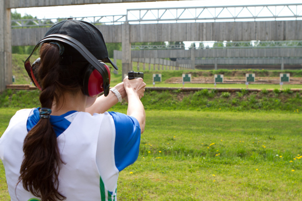 woman shooting in shooting range in open field