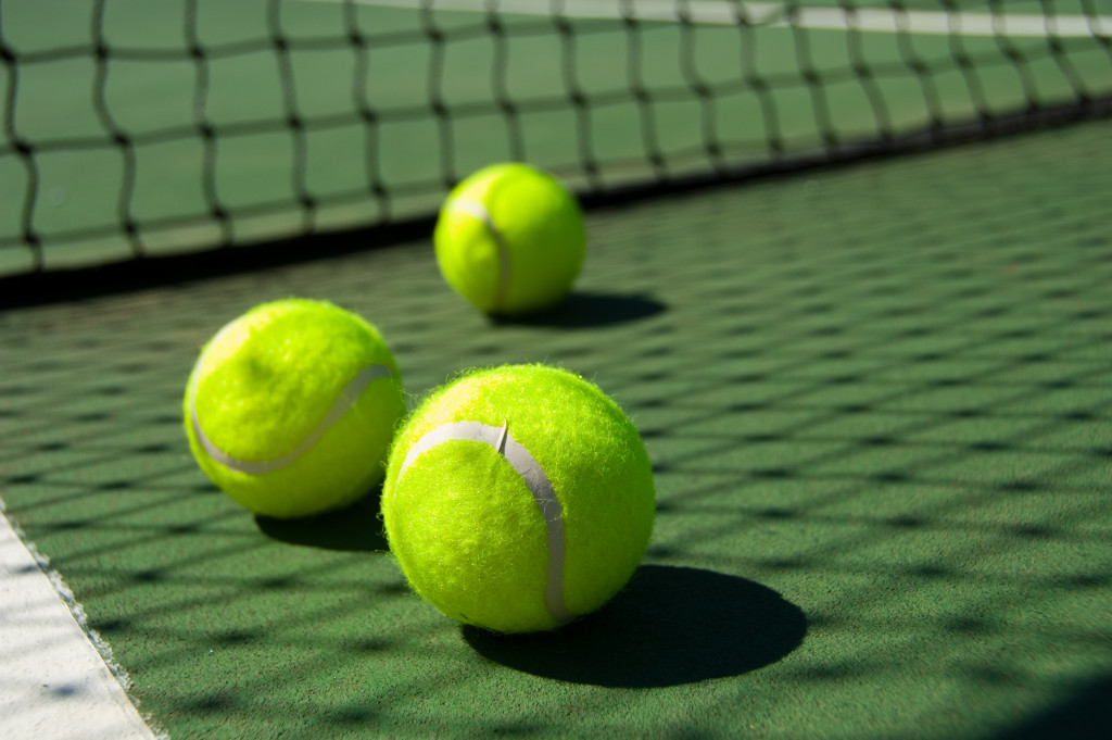 Three tennis balls on a tennis court