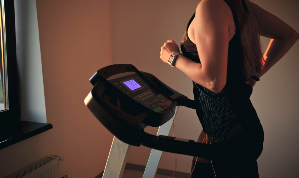 Young woman exercising on a treadmill at home.