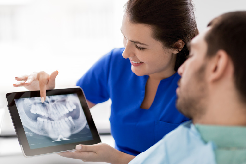 A dentist showing her patient his dental x-ray