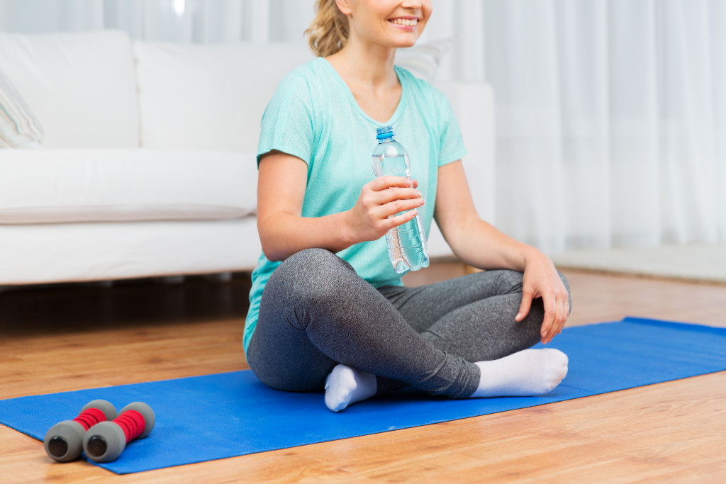 A woman about to drink water after working out at home