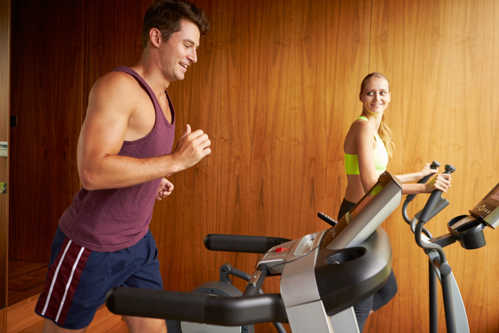 Young couple exercising together in their home gym.