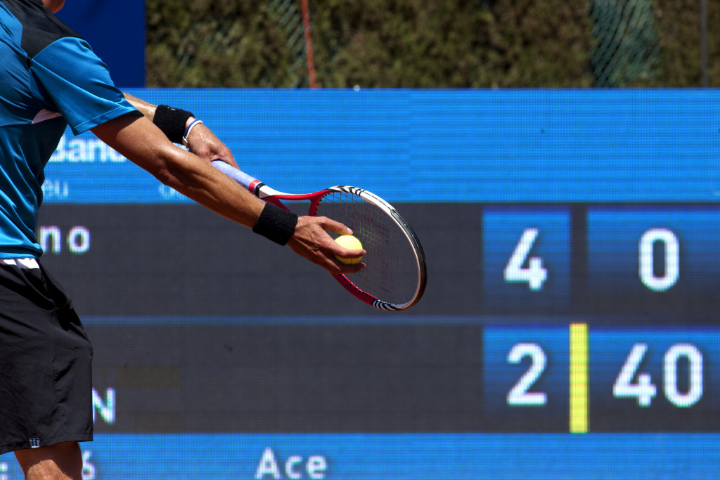 A tennis player holding a racket before service