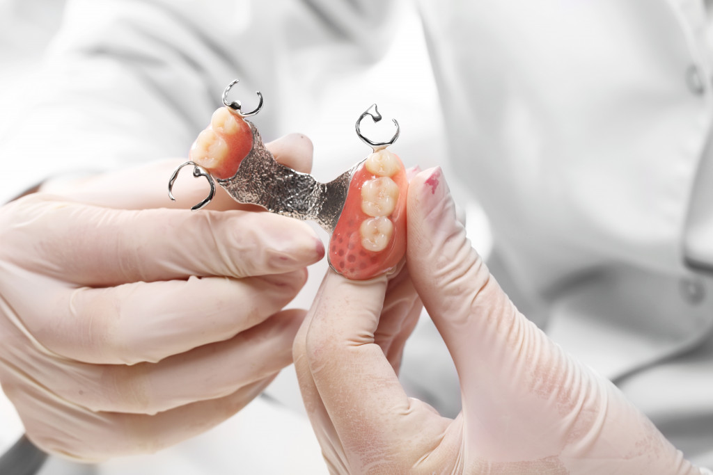 dentist holding a set of dentures concept of cosmetic dentistry