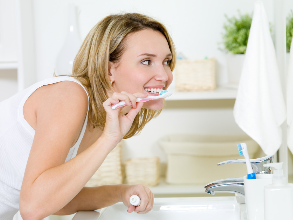 woman in the restroom brushing her teeth