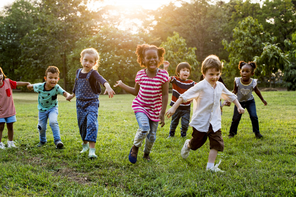 kids smiling while running around in the grass