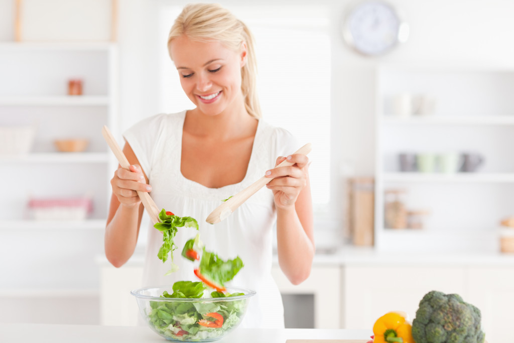 mixing vegetable salad in the kitchen