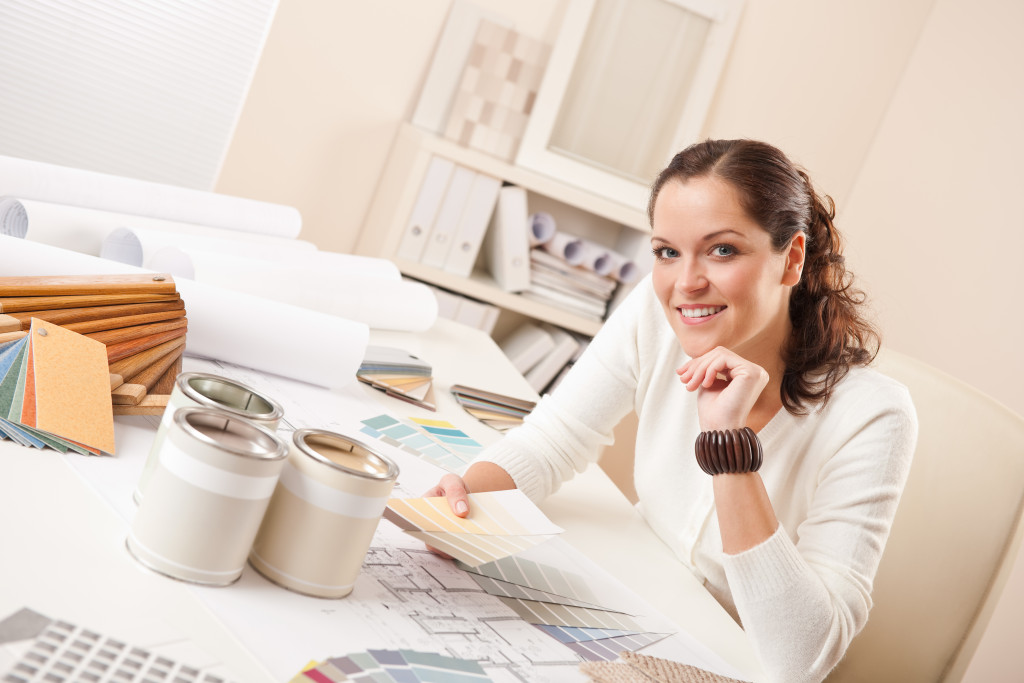 female interior designer with color palette and floor plan in her table