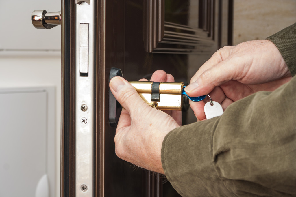 A locksmith fixing, replacing a house door lock