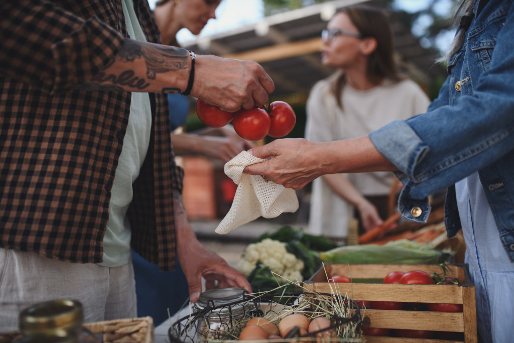 A woman buying tomatoes from a local market