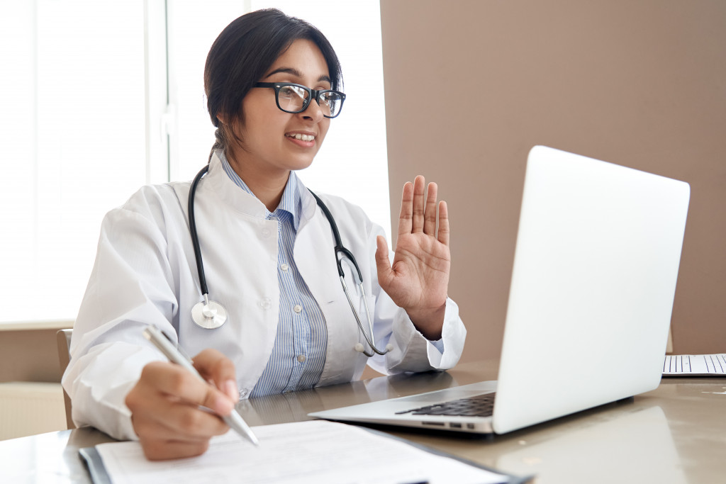 A doctor talking to a patient through video conference via telemedicine