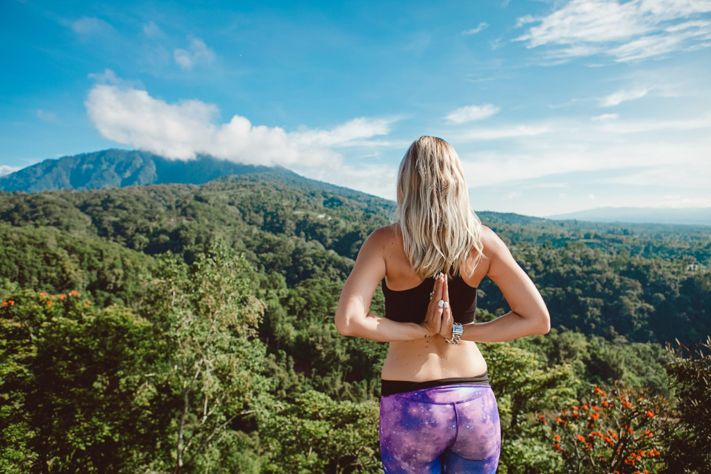 woman doing yoga around nature