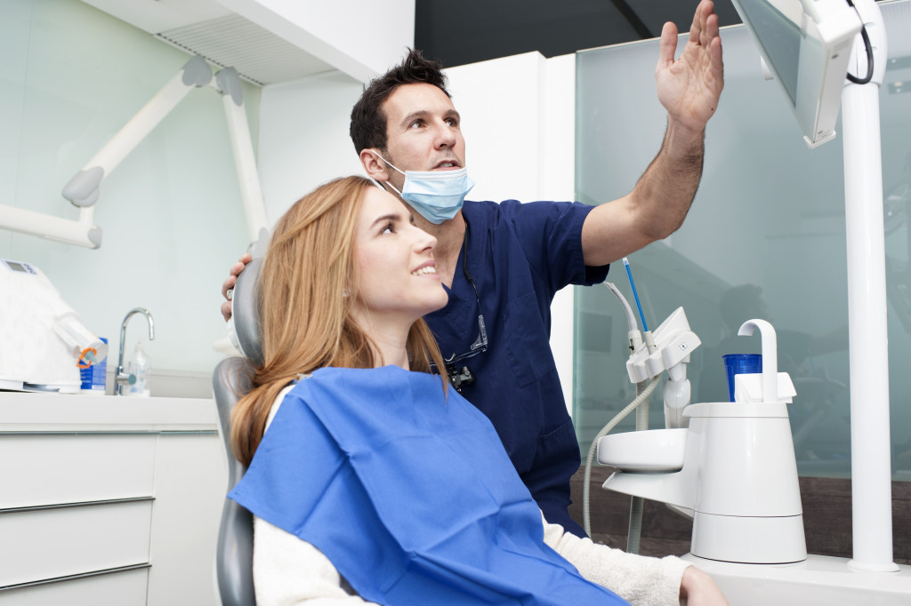 dentist showing something to female patient