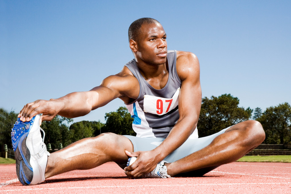 male athlete warming up and stretching