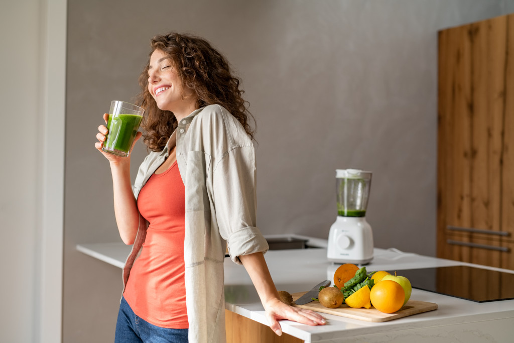 woman drinking green smoothie for a healthy diet