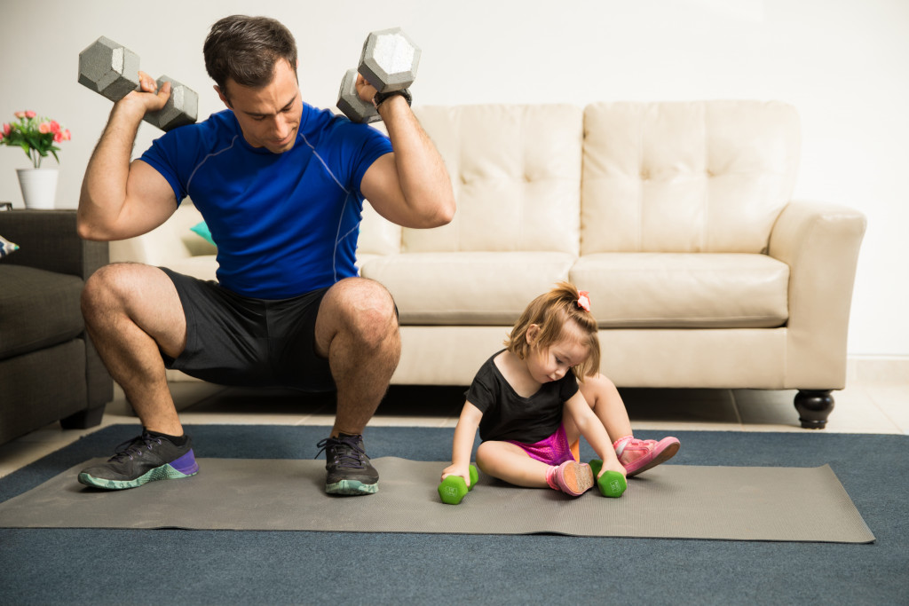 a dad working out with his daughter at home